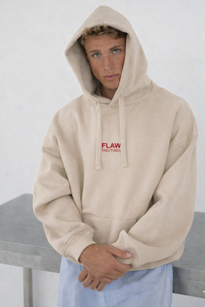 Modelo usando polerón canguro oversized color crudo FLAW con logo frontal rojo